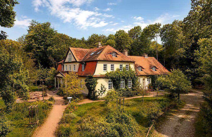 Das Gutshaus mit Efeu und Garten im Sommer